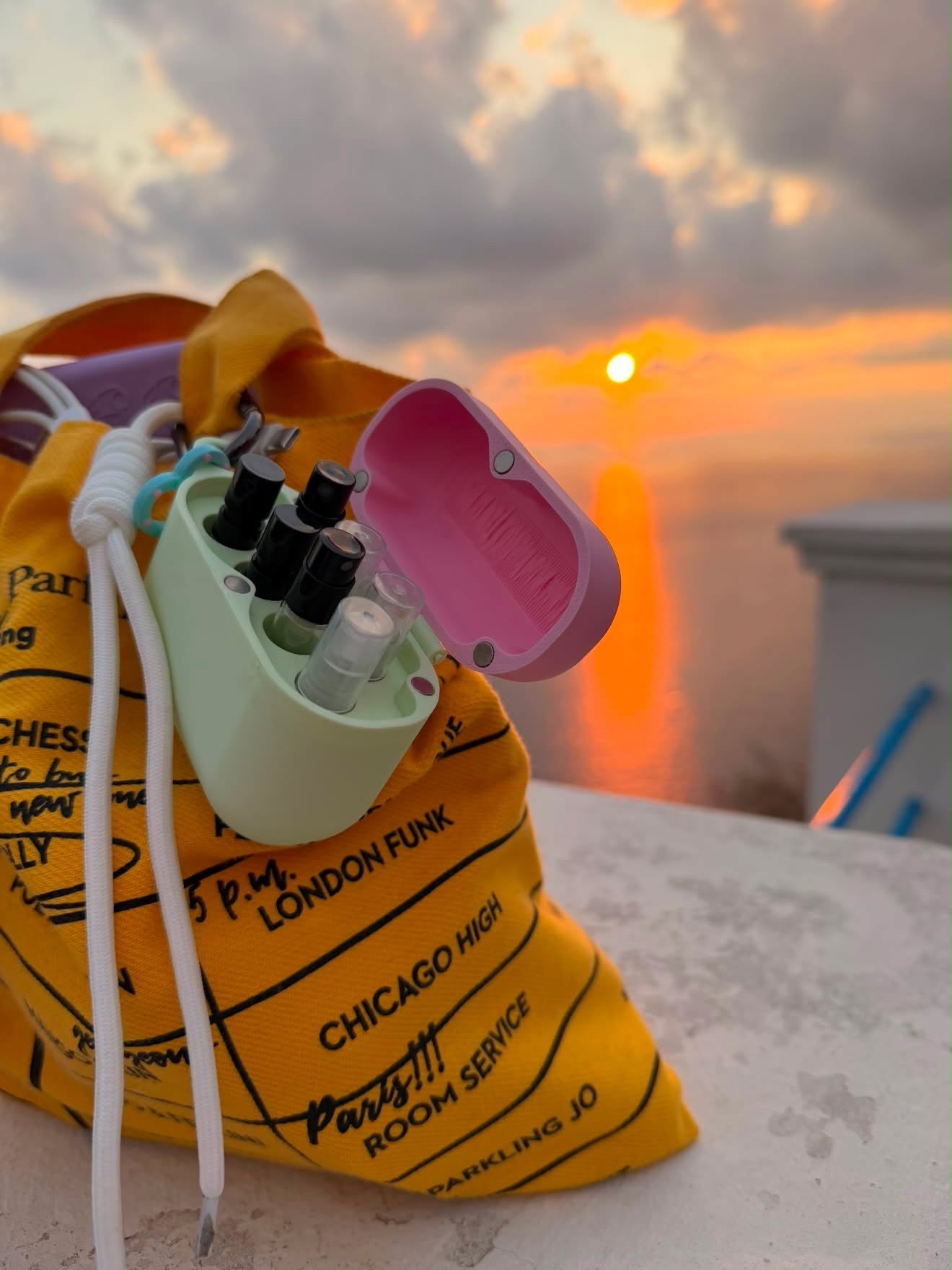 ScentPod verde menta agganciato a una borsa al tramonto