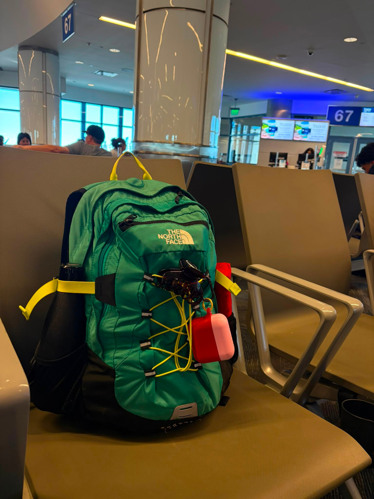 ScentPod rosa agganciato a uno zaino in aeroporto